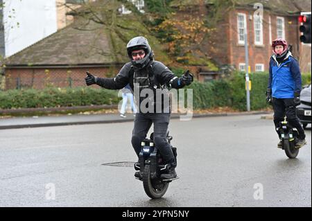 Cambridge, Angleterre, 30 November 2024, Royaume-Uni. Les adultes circulent en Segway le long de la route principale Banque D'Images