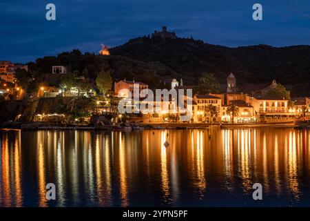 Hôtels illuminés, bars et restaurants sur la promenade de la plage de Collioure en contrebas du Fort Saint-Elme au crépuscule, Languedoc-Roussillion, France Banque D'Images