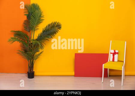 Cadeau festif sur une chaise à l'intérieur d'un salon jaune et orange Banque D'Images