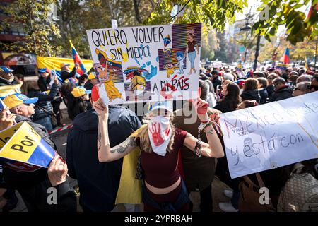 Madrid, Espagne. 1er décembre 2024. Les manifestants tiennent des pancartes exprimant leur opinion pendant la manifestation. Des centaines de Vénézuéliens se sont rassemblés à Madrid, devant la représentation de la Commission du Parlement européen en Espagne pour manifester contre le régime vénézuélien et réclamer la liberté du Venezuela face à une possible fraude électorale de Nicolas Maduro. Crédit : SOPA images Limited/Alamy Live News Banque D'Images