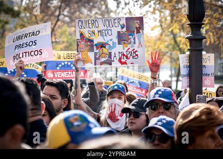 Madrid, Espagne. 1er décembre 2024. Les manifestants tiennent des pancartes exprimant leur opinion pendant la manifestation. Des centaines de Vénézuéliens se sont rassemblés à Madrid, devant la représentation de la Commission du Parlement européen en Espagne pour manifester contre le régime vénézuélien et réclamer la liberté du Venezuela face à une possible fraude électorale de Nicolas Maduro. Crédit : SOPA images Limited/Alamy Live News Banque D'Images