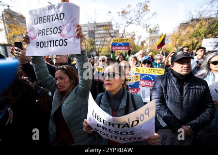 Madrid, Espagne. 1er décembre 2024. Les manifestants tiennent des pancartes exprimant leur opinion pendant la manifestation. Des centaines de Vénézuéliens se sont rassemblés à Madrid, devant la représentation de la Commission du Parlement européen en Espagne pour manifester contre le régime vénézuélien et réclamer la liberté du Venezuela face à une possible fraude électorale de Nicolas Maduro. Crédit : SOPA images Limited/Alamy Live News Banque D'Images