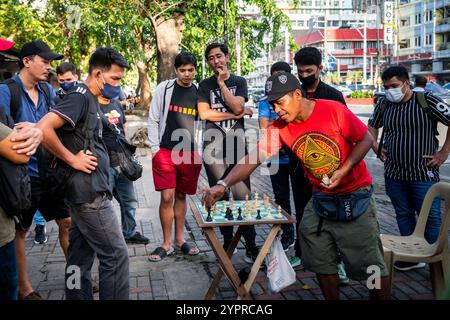 Les hommes philippins profitent d'une partie d'échecs dans les rues de Manille à l'extérieur de Rizal Park, Ermita District, Manille, Philippines. Banque D'Images