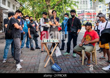 Les hommes philippins profitent d'une partie d'échecs dans les rues de Manille à l'extérieur de Rizal Park, Ermita District, Manille, Philippines. Banque D'Images