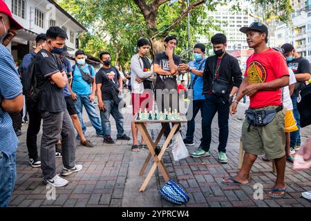 Les hommes philippins profitent d'une partie d'échecs dans les rues de Manille à l'extérieur de Rizal Park, Ermita District, Manille, Philippines. Banque D'Images