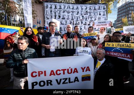 Madrid, Espagne. 1er décembre 2024. Les manifestants portent une banderole exigeant que la Cour pénale internationale prenne des mesures contre Nicolas Maduro lors d'une manifestation. Des centaines de Vénézuéliens se sont rassemblés à Madrid, devant la représentation de la Commission du Parlement européen en Espagne pour manifester contre le régime vénézuélien et réclamer la liberté du Venezuela face à une possible fraude électorale de Nicolas Maduro. (Photo de Diego Radames/SOPA images/SIPA USA) crédit : SIPA USA/Alamy Live News Banque D'Images