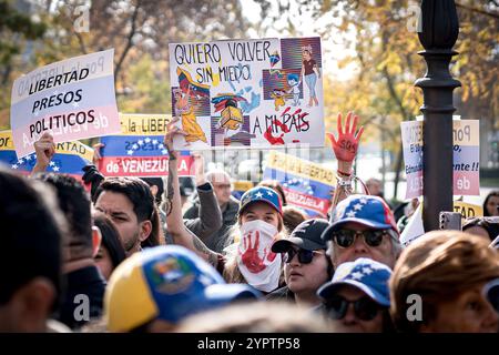 Madrid, Espagne. 1er décembre 2024. Les manifestants tiennent des pancartes exprimant leur opinion pendant la manifestation. Des centaines de Vénézuéliens se sont rassemblés à Madrid, devant la représentation de la Commission du Parlement européen en Espagne pour manifester contre le régime vénézuélien et réclamer la liberté du Venezuela face à une possible fraude électorale de Nicolas Maduro. (Photo de Diego Radames/SOPA images/SIPA USA) crédit : SIPA USA/Alamy Live News Banque D'Images