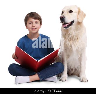 Garçon lisant le livre avec son chien mignon sur fond blanc Banque D'Images