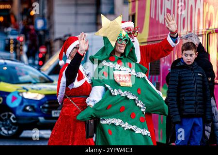 Liverpool, Royaume-Uni. 1er décembre 2024. Un participant porte une robe fantaisie de sapin de Noël pendant le Liverpool Santa Dash. Les participants ont enfilé des costumes rouges (et bleus) du Père Noël le long d'un parcours de 5 km autour du centre-ville de Liverpool pour soutenir le Claire House Children's Hospice. 8 500 personnes ont participé à la 20e édition annuelle de Liverpool Santa Dash. (Crédit image : © Andy von Pip/SOPA images via ZUMA Press Wire) USAGE ÉDITORIAL SEULEMENT! Non destiné à UN USAGE commercial ! Banque D'Images