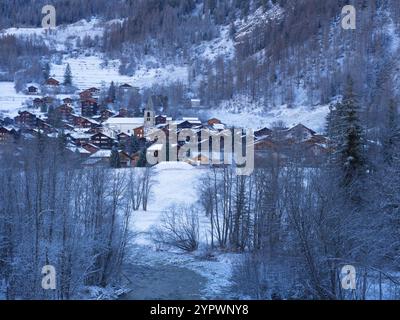 Tôt le matin vue à travers la vallée, vers Evolene dans le Val d'Herens, Suisse, un beau et célèbre village historique entouré de terres d'hiver Banque D'Images