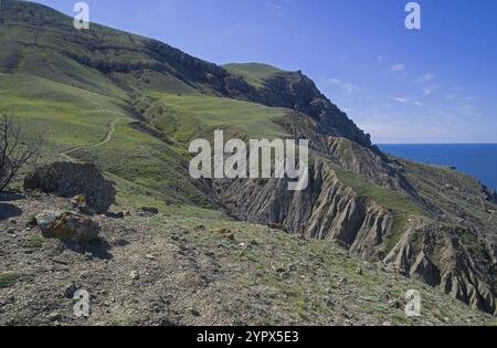 Traces d’érosion et d’altération des sols sur la pente abrupte du cap Meganom face à la mer. Crimée, une journée ensoleillée en avril Banque D'Images