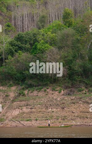 Fleuve Mékong, Laos - 9 avril 2011 : homme dans un bateau sur le fleuve Mékong près de Lauang Prabang, Laos Banque D'Images