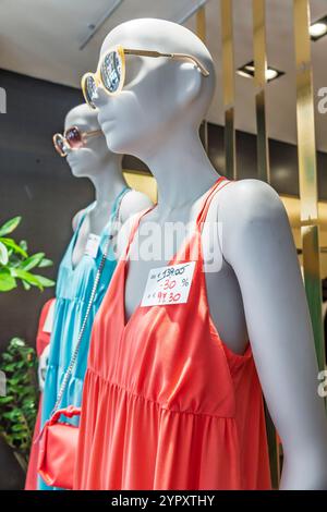 Civitavecchia Italie, près de Piazzetta Santa Maria, affichage de mannequins, boutique de mode, vente de robes d'été, vêtements turquoise corail, étiquettes de prix avec Banque D'Images