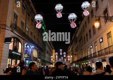 Lisbonne, Portugal - les gens marchant dans la rue du centre-ville la nuit avec des lumières de Noël Banque D'Images