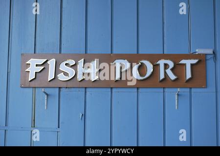 Un panneau de port de poisson magnifiquement conçu affiché sur un charmant mur en bois bleu Banque D'Images