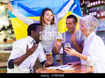 Heureux fans célébrant la victoire de l'équipe ukrainienne au bar Banque D'Images