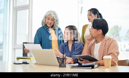 Une équipe de start-up asiatique brainstorming, partageant des idées créatives et utiles, et discutant d'un projet dans un bureau moderne. Un patron féminin senior WO Banque D'Images