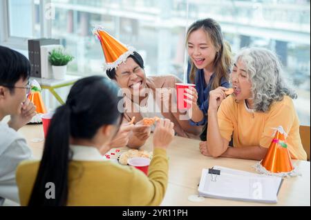 Un groupe de joyeux entrepreneurs asiatiques diversifiés célèbrent dans le bureau, riant, discutant et dégustant des boissons. team building, partie corporative Banque D'Images