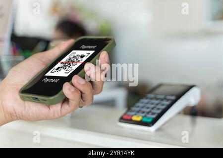 Focus sur scanner ici pour payer du texte, gros plan des mains Scaning QR code pour le contact numérique moins de paiement après achat - concept de technologie, de sécurité et Banque D'Images