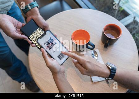 Concentrez-vous sur le texte Scan Here to Pay. Gros plan des mains scaning QR code pour le contact numérique moins de paiement après l'achat - concept de technologie, de sécurité et Banque D'Images