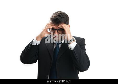 Entrepreneur masculin stressé portant un costume d'affaires ayant mal à la tête tenant le front avec les mains isolées sur fond blanc de studio Banque D'Images
