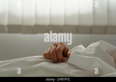 Gros plan de la main de l'homme sur une couverture, homme endormi Banque D'Images