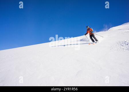 Le skieur descend en faisant des pistes fraîches le jour ensoleillé d'hiver, Whistler Banque D'Images