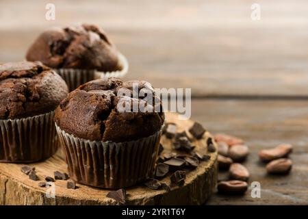 Muffins aux pépites de chocolat avec du chocolat sur une table en bois. Banque D'Images