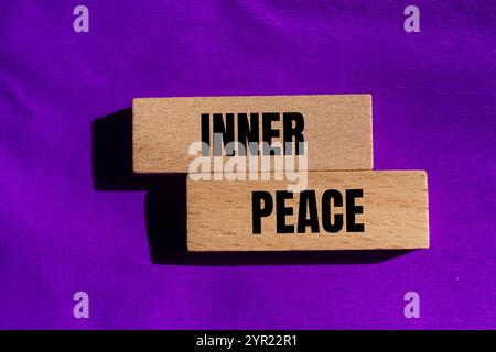 Message de paix intérieur écrit sur des blocs de bois avec fond violet. Symbole conceptuel de paix intérieure. Copier l'espace. Banque D'Images