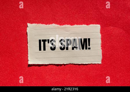 C'est un message de spam écrit sur un morceau de papier déchiré déchiré avec un fond rouge. Conceptuel, c'est le symbole spam. Copier l'espace. Banque D'Images