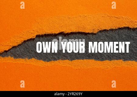 Own Your moment message écrit sur papier orange déchiré déchiré avec fond gris. Symbole conceptuel à l'image de votre moment. Copier l'espace. Banque D'Images