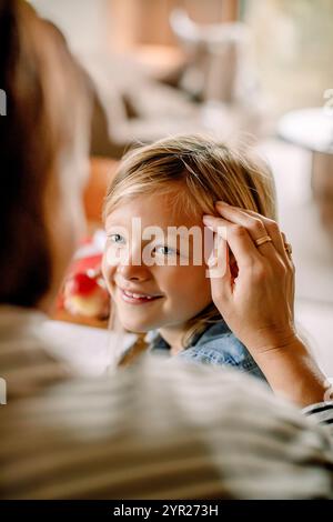 Vue au-dessus de l'épaule de la mère passant du temps libre avec son fils à la maison Banque D'Images