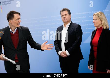 02 décembre 2024, Berlin : Karl Lauterbach (SPD), ministre fédéral de la santé, intervient lors de la remise du plan d'action pour un système de santé diversifié, inclusif et sans obstacles à Jürgen Dusel (M), commissaire du gouvernement fédéral pour les questions relatives aux personnes handicapées, et Verena Bentele (R), porte-parole du Conseil allemand pour les personnes handicapées au ministère fédéral de la santé. Photo : Carsten Koall/dpa Banque D'Images