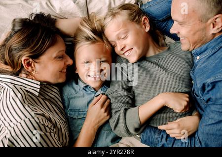 Directement au-dessus de la photo d'une famille heureuse couchée côte à côte à la maison Banque D'Images