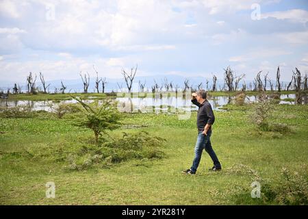 02 décembre 2024, Kenya, Village de Sulmac : Robert Habeck (Alliance 90/les Verts), ministre fédéral de l’économie et de la protection du climat, marche devant des arbres morts lors d’une visite au lac Naivasha. Les arbres du lac meurent parce que l'eau monte en raison du changement climatique. Habeck assiste au 5ème Sommet économique germano-africain au Kenya. Photo : Sebastian Christoph Gollnow/dpa Banque D'Images