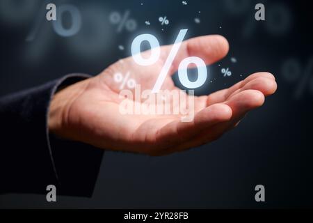 Taux d'intérêt, dividende et concept d'escompte. Gros plan de la main masculine avec le symbole de pourcentage. Mise au point sélective Banque D'Images