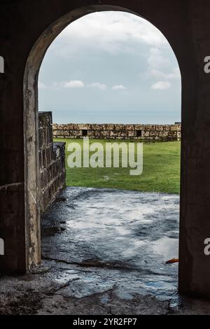 George's, Grenade - 4 janvier 2018 : une vue à travers une arche à Fort Frederick, surplombant la pelouse verdoyante et la mer lointaine. Banque D'Images