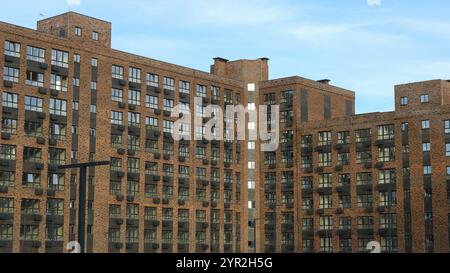 grand complexe résidentiel de plusieurs étages en brique brune, vue de l'extérieur, nouvel appartement bâtiment moderne avec de nombreuses fenêtres et boîtes en métal Banque D'Images