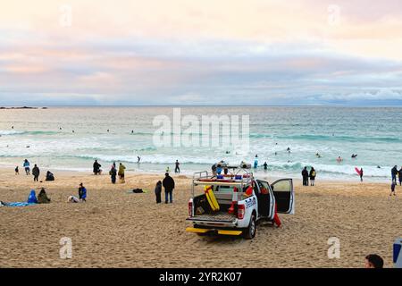 Porthmeor plage au crépuscule un jour d'automne avec quelques surfeurs robustes dans la mer St Ives Cornwall Angleterre Banque D'Images