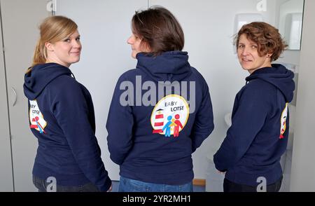 Rostock, Allemagne. 02 décembre 2024. Marie Hagen (gauche-droite), Mandy Berlin et Nadine Schlefske sont des guides pour bébés au Klinikum Südstadt Rostock (KSR), portant leur logo sur le dos. Ils aident les femmes enceintes et les jeunes familles à démarrer dans une grande variété de domaines. Le spectre va de la bureaucratie et des questions de santé à des problèmes tels que l'itinérance et la violence. Selon Klinikum Südstadt Rostock, ce service est unique en Mecklembourg-Poméranie occidentale et devient permanent après une phase pilote. Crédit : Bernd Wüstneck/dpa/Alamy Live News Banque D'Images