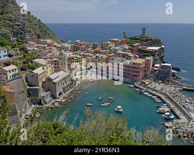 Faisant partie de la célèbre région italienne des Cinque Terre, le village coloré de Vernazza est représenté avec le golfe de Gênes en arrière-plan pendant une journée d'été. Banque D'Images