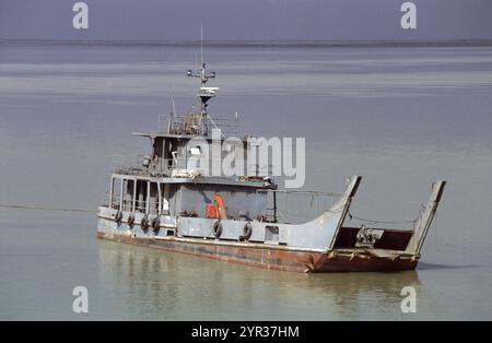 Première guerre du Golfe : 15 mars 1991. Une embarcation de débarquement endommagée de l'armée irakienne abandonnée dans les bas-fonds près de l'extrémité continentale du pont menant à l'île de Bubiyan au nord-est du Koweït. Banque D'Images