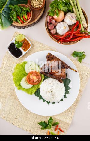 Bebek Bakar ou canard rôti au Sambal Terasi, une nourriture traditionnelle indonésienne typique de Java occidental. Cette nourriture est servie avec du riz, du concombre, de la tomate Banque D'Images