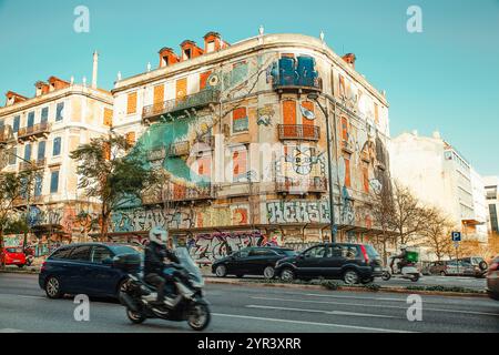 Un bâtiment abandonné avec des fenêtres en briques et une peinture murale lumineuse sur la façade à Lisbonne, Portugal, le 28 février 2020. Banque D'Images