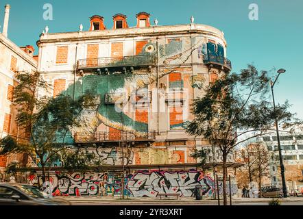 Un bâtiment abandonné avec des fenêtres en briques et une peinture murale lumineuse sur la façade à Lisbonne, Portugal, le 28 février 2020. Banque D'Images