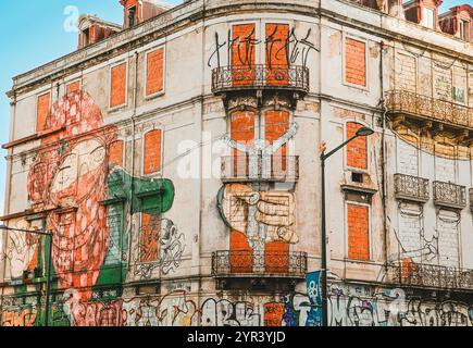 Un bâtiment abandonné avec des fenêtres en briques et une peinture murale lumineuse sur la façade à Lisbonne, Portugal, le 28 février 2020. Banque D'Images