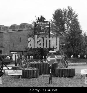 Emsworth, Hampshire, Angleterre. 26 août 2024. Vue en niveaux de gris du panneau d'accueil de la ville qui se dresse sur un rond-point. Banque D'Images