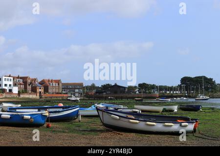 Emsworth, Hampshire, Angleterre. 26 août 2024. Vue en couleur d'une partie du port à marée basse avec des bateaux sur des algues et des algues, des bâtiments à l'horizon. Banque D'Images