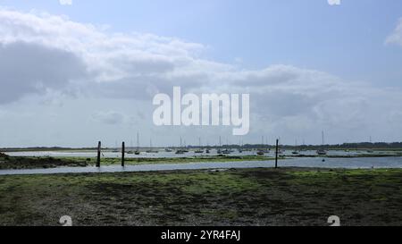 Emsworth, Hampshire, Angleterre. 26 août 2024. Grand angle, vue en couleur d'un paysage marin à marée basse avec un ciel bleu et des nuages au-dessus. Banque D'Images