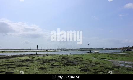 Emsworth, Hampshire, Angleterre. 26 août 2024. Vue grand angle sur la plage et le port sous un ciel bleu avec quelques nuages. Banque D'Images